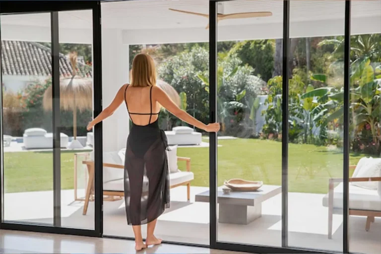 Fechamento em vidro com portas de correr para o jardim